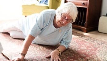 Elderly woman on the floor, reaching for help. Senior woman in distress, needs assistance. Elderly care, safety for senior woman. Emergency for elderly woman. Senior woman on the floor need help.