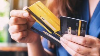 a_woman_holding_and_choosing_credit_card_to_use_picture_id1172101452-37034218