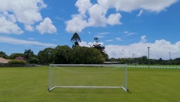 empty-soccer-goal-green-grass-field-blue-sky