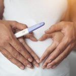 pregnant_woman_her_husband_hand_showing_heart_shape-37021288