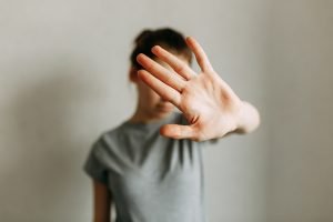 Domestic violence against women. The girl covers her face with her hand and asks for help. Stop domestic violence.